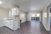 Located at 555 E Fruitvale Ave in Hemet, CA, this single-floor residence offers two bedrooms and two bathrooms within a well-organized layout. The living area features wood-style flooring and a ceiling fan, with a sliding glass door that fills the room with natural light and opens to an outdoor balcony with exterior views. The galley-style kitchen is thoughtfully designed with ample white cabinetry, granite-look countertops, a stainless steel sink, and a white range, all accented by durable wood-style flooring. Both bedrooms are carpeted for comfort, each featuring textured ceilings and large windows or sliding glass doors that invite natural light. The primary bedroom includes direct access to a dedicated bathroom and a closet, offering a convenient private retreat. The two bathrooms are well-appointed; one features a dual-sink vanity with granite-look countertops and wood-style flooring, while the other includes a full tub-shower combination with clean white surround. Neutral warm-beige tones flow throughout the unit, creating a cohesive and inviting atmosphere. Textured ceilings are consistent across all rooms, adding a classic finishing detail to this functional and comfortable Hemet residence.
