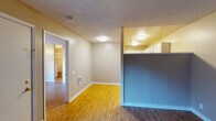 This single-floor unit offers a practical and comfortable layout designed for everyday living. The living and dining areas are connected by an open flow, distinguished by warm honey-toned laminate flooring that transitions seamlessly throughout the main spaces. A half-wall partition with a blue accent separates the living area from the kitchen, creating a sense of definition while maintaining an open feel. Flush-mount ceiling lights provide consistent illumination, and textured popcorn ceilings add a classic character to the space.

The kitchen is well-equipped with stainless steel appliances, including a refrigerator, electric range, over-the-range microwave, and dishwasher. White cabinetry with dark granite-style countertops lines the walls, offering ample storage and prep space, all complemented by the same light laminate flooring.

The bedroom is a generously sized, quiet retreat featuring a window that allows natural light to filter in, with views to the outdoors. Rich, dark wood-toned laminate flooring grounds the room, and a walk-in closet provides excellent storage. The full bathroom includes a single-sink vanity with white cabinetry, a large mirror with overhead lighting, and a shower-tub combination, finished in a clean, neutral palette.