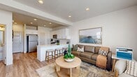Located at 2640 S Table Butte Ln in Magna, Utah, this two-story home offers a well-designed layout across two floors. The main level features an open-concept kitchen and living area bathed in natural light, with recessed lighting, light wood-look flooring, and a clean, neutral color palette throughout. The kitchen is equipped with white shaker cabinetry, a subway tile backsplash, stainless steel appliances including a refrigerator and microwave, and a breakfast bar with seating — ideal for casual dining and entertaining. A convenient half bath is also located on the main level. The upper floor hosts three bedrooms, each with plush carpeting and windows that bring in natural light. The generously sized primary bedroom includes its own dedicated closet with built-in shelving and hanging rods, as well as an en-suite bathroom featuring a soaking tub. The additional bedrooms are well-proportioned and versatile, with one currently configured as a home office, demonstrating the flexibility of the layout. Two additional full bathrooms serve the upper level, each finished with white cabinetry and clean, modern fixtures. Three closets throughout the home provide ample storage. The overall aesthetic is bright, contemporary, and move-in ready.