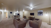 This single-floor unit in Oxford, Ohio offers a well-organized layout designed for comfortable everyday living. The open-concept living and dining area is generously sized, featuring plush carpeting, a ceiling fan with integrated lighting, and seamless sight lines into the kitchen. The living space accommodates multiple seating arrangements and includes a wall-mounted television setup, making it ideal for both relaxing and entertaining.

The kitchen is outfitted with warm-toned wooden cabinetry, dark granite-style countertops, tile flooring, and black appliances including a refrigerator, electric range, and over-the-range microwave. A breakfast bar with bar seating connects the kitchen to the living area, reinforcing the open flow of the space.

Each bedroom is carpeted and features a sliding closet, a built-in desk workspace, and a window that allows natural light to filter in. The bedrooms offer a quiet, functional environment suited for study or rest.

Two full bathrooms are present, each featuring a single-sink vanity with wood cabinetry, a tub-shower combination, and tile flooring. The floorplan also incorporates an in-unit laundry area, adding a practical convenience to the overall layout.