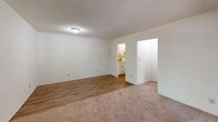Located at 740 Smallwood Dr in Raleigh, NC, this one-bedroom, one-bathroom unit offers a practical and well-organized single-floor layout. The living room is a bright, open space featuring a mix of hardwood-style flooring and carpet, neutral walls, and a textured ceiling, creating a comfortable and versatile area. It flows naturally toward the kitchen, which is efficiently designed with white cabinetry, laminate countertops, a coil-top electric range, a stainless steel sink, and a full-size refrigerator — all finished in a warm, light-toned palette. A dedicated pantry adds valuable storage to the kitchen area. The dining room provides a defined space for everyday meals, conveniently situated near the kitchen. The bedroom is a well-proportioned, carpeted room with a window that allows natural light and outdoor views, complemented by a closet for storage. The bathroom features a full tub-shower combination with classic white tile surround, a vanity with a wide mirror, and white cabinetry below. Three closets throughout the unit offer ample storage. A connecting hallway ties the spaces together cohesively. The unit's clean, neutral finishes throughout make it a functional and move-in-ready space.