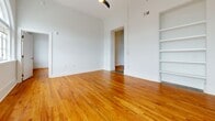Located at 320 Talley St in Columbia, SC, this one-bedroom, one-bathroom unit offers a well-designed layout across a single floor. Rich, warm-toned hardwood flooring flows consistently throughout the living areas and bedroom, lending a classic character to the space.

The kitchen is a standout feature, showcasing white shaker-style cabinetry with modern black hardware, granite countertops, a subway tile backsplash, and a full suite of stainless steel appliances including a refrigerator, dishwasher, electric range, and microwave. The kitchen connects seamlessly to the adjacent living area, which benefits from tall ceilings that enhance the sense of openness. Built-in shelving units provide both functional storage and display opportunities, adding a distinctive architectural touch.

The bedroom is a comfortable, well-proportioned room with the same warm hardwood flooring and crisp white walls, creating a clean and serene retreat. An elegant arched doorway detail adds a touch of classic architectural charm.

The bathroom is finished in a clean, minimal style, featuring a full-sized soaking tub with shower combination and neutral tile flooring. A connecting hallway ties the layout together efficiently. The overall ambiance is bright and inviting, with white walls throughout maximizing the sense of light and space.