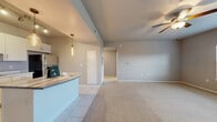 This single-story residence in Oklahoma City, OK offers a functional and comfortable layout comprising one bedroom, two bathrooms, a living room, kitchen, closet, and hallway. The open-concept living and kitchen area features a seamless transition between tile flooring in the kitchen and plush carpeting in the living space, creating a warm, cohesive atmosphere. A ceiling fan overhead adds comfort, while a pendant light above the kitchen peninsula adds a modern touch.

The kitchen is well-equipped with white shaker-style cabinetry, laminate countertops, stainless steel appliances including a range, over-the-range microwave, and dishwasher, all set on clean tile flooring. A breakfast bar peninsula provides additional prep and dining space.

The bedroom is a comfortable retreat featuring soft carpet, a ceiling fan with light fixture, and a trio of windows that invite natural light and outdoor views. The room connects to a generously sized walk-in closet outfitted with wire shelving along multiple walls, offering ample storage.

Additional highlights include a dedicated laundry area with washer hookups, tile flooring, and an electrical panel conveniently housed within the space. Neutral tones throughout create a clean, move-in-ready environment suited for a variety of décor styles.