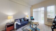 Located at 4701 Seventh Ave SW in Olympia, Washington, this single-floor unit offers a well-organized and comfortable layout designed for everyday living. The living room serves as the central gathering space, featuring plush carpeting, notably high ceilings that lend an open and airy feel, and large sliding glass doors fitted with vertical blinds that invite generous natural light and provide outdoor views. The space is well-suited for a variety of furniture arrangements.

The kitchen is efficiently laid out with warm-toned wood cabinetry offering ample storage, neutral countertops, a double-basin stainless steel sink, and a full suite of white appliances including a refrigerator, electric range, and built-in microwave. Light hardwood-style flooring runs throughout the kitchen, adding a clean, bright contrast to the cabinetry.

Multiple bedrooms feature soft carpeting, baseboard heating, and windows with vertical blinds that allow for natural light while maintaining privacy. The rooms offer clean, neutral walls that provide a versatile backdrop for any décor style.

The bathroom is finished with hardwood-style flooring, warm wood vanity cabinetry, a large mirror with overhead lighting, and a full tub-shower combination. The overall aesthetic of this unit is clean and neutral, creating a move-in-ready environment in a convenient Olympia location.