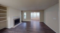 Located at 7816 Calibre Crossing Dr in Charlotte, NC, this single-floor residence offers a well-organized layout with a mix of practical and comfortable living spaces. The open living and dining area serves as the heart of the home, featuring rich, dark hardwood-style flooring that extends throughout the main areas. A tile-surround fireplace anchors the living room, accompanied by built-in shelving that adds both character and storage. Multiple windows fitted with blinds allow natural light to fill the space, creating a bright and welcoming atmosphere.

The galley-style kitchen is efficiently designed with white cabinetry, light stone countertops, subway tile backsplash, and black appliances including a gas range and refrigerator. An interior pass-through window connects the kitchen visually to the main living area. A dedicated laundry space houses a full-sized washer and dryer, adding everyday convenience.

The bedroom features plush carpeting and a window that brings in natural light. The bathroom includes a full tub-shower combination with brushed nickel fixtures. Additional built-in shelving in the hallway provides versatile storage. Textured ceilings are present throughout, contributing to the home's overall character.