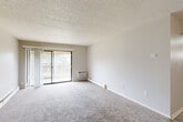 Located at 2740 Fleur Dr in Des Moines, Iowa, this two-bedroom, one-bathroom unit offers a practical and well-organized single-floor layout. The living room is a comfortable, carpeted space highlighted by a sliding glass door that opens onto a private balcony, allowing natural light to fill the room and offering outdoor views. A wall-mounted HVAC unit and baseboard heating provide year-round climate control. The textured ceiling adds a classic character throughout the living areas.

The kitchen features warm-toned oak cabinetry, a full-size refrigerator, a gas range, and a sink with countertop workspace, all set on easy-to-maintain wood-look vinyl flooring. Overhead fluorescent lighting ensures a bright, functional cooking environment.

The primary bedroom is a generously sized, carpeted room with a sliding-door closet offering ample storage. The second bedroom, also carpeted, includes a window that brings in natural light. Both bedrooms benefit from baseboard heating. The full bathroom is clean and straightforward, featuring a tub-shower combination with tiled surround, a toilet, and wood-look vinyl flooring. A hallway connects the main living areas to the bedrooms and bathroom, providing a cohesive and efficient flow throughout the unit.