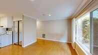 Located at 1901 Montecito Avenue in Mountain View, California, this efficiently designed single-floor unit offers a thoughtful layout across its cozy footprint. Warm-toned hardwood flooring runs throughout the main living areas, lending continuity and warmth to the space.

The living room is bright and inviting, featuring crown molding, recessed lighting, and a large window that frames views of surrounding greenery, allowing natural light to fill the room. A wall-mounted heater vent adds a practical touch to the clean, neutral-toned walls.

The combined dining room and kitchen area is positioned for convenience, equipped with a white electric range, a full-size refrigerator, and granite countertops — providing essential functionality in a compact arrangement. A wall-mounted light fixture illuminates the kitchen workspace.

The hallway connects the main living area to the bathroom and two closets, offering practical storage solutions. The bathroom features a full soaking tub with a shower, chrome fixtures, and neutral wall surrounds, maintaining the clean and understated aesthetic found throughout the unit.

The entryway greets visitors with a classic white door accented by an arched window, adding a subtle architectural detail. Crown molding and recessed lighting appear consistently across rooms, contributing to a polished, cohesive interior finish throughout this Mountain View residence.