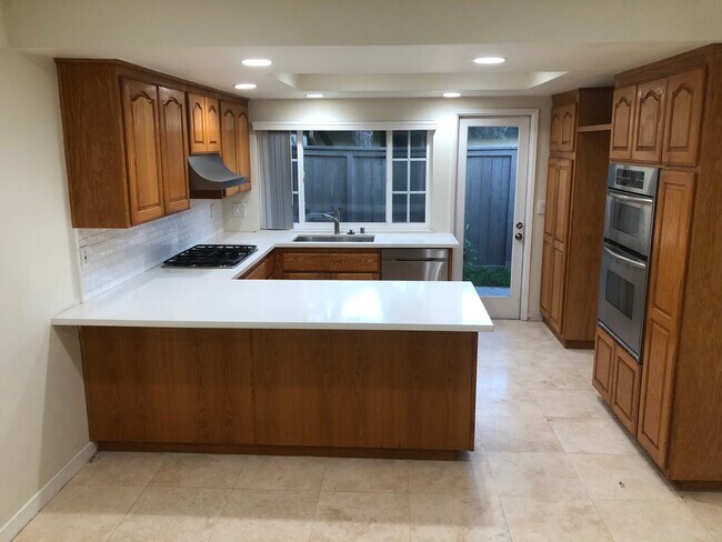 New white quartz countertops with gas cooktop. Built-in microwave and oven. - 10175 El Corazon Ave