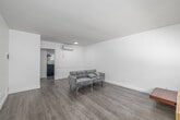 Located at 1216 W 37th Pl in Los Angeles, CA, this well-maintained 2-bedroom, 1-bathroom unit offers a thoughtfully designed single-level layout. The interior is defined by a consistent palette of crisp white walls and light wood-tone vinyl plank flooring that flows throughout the entire space, creating a clean and cohesive aesthetic.

The living room is an open, airy space equipped with a wall-mounted mini-split A/C unit and direct sightlines into the kitchen, making it ideal for everyday living. The kitchen features white shaker-style cabinetry with ample upper and lower storage, light quartz countertops, a stainless steel sink, and a gas range, offering a functional and modern cooking environment.

Both bedrooms are comfortably sized with white walls and natural light provided by windows with blinds. The primary bedroom includes a wall-mounted A/C unit and a dedicated closet, while the second bedroom also features its own closet for convenient storage. A connecting hallway links the rooms efficiently.

The bathroom is neatly finished with large-format marble-look tile surrounding a tub-shower combo with a sliding glass enclosure, brushed nickel fixtures, a white vanity, and a mirrored medicine cabinet. The unit also includes a dedicated hallway connecting all rooms for a practical and organized flow throughout.