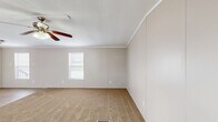 Located at 9101 Normandy Boulevard in Jacksonville, Florida, this single-story, 3-bedroom, 2-bathroom home offers a practical and efficient layout. The living room welcomes you through a front entrance door with a decorative diamond window, and is finished with neutral carpet, crown molding, and a ceiling fan with light fixture, with windows providing natural light. The open flow connects to the dining room and kitchen, which features white cabinetry, a full-size refrigerator, and wood-look vinyl flooring that continues through the hallway and wet areas. A dedicated laundry area is conveniently tucked along the hallway. The spacious primary bedroom includes a ceiling fan, a window for natural light, and closet access. Two additional bedrooms are carpeted with closets and ceiling-mounted light fixtures. Both bathrooms are finished with wood-look vinyl flooring, white vanities, and full tub-shower combinations. The primary bath includes a large mirror with vanity lighting above the sink. With four closets throughout, the home offers ample storage. The neutral color palette and clean finishes give the home a bright, move-in ready feel.