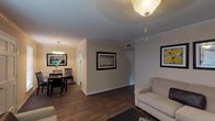 Located at 4944 S Sherwood Forest Blvd in Baton Rouge, Louisiana, this single-floor residence offers a well-organized layout designed for comfortable everyday living. The living room is a welcoming central space featuring dark hardwood-style flooring, crown molding, a textured ceiling, and a ceiling fan with light fixture. The room provides ample space for seating and entertainment. Adjacent to the living area, the dining room benefits from natural light through a window with blinds and is anchored by an elegant chandelier, creating an inviting atmosphere for meals. The galley-style kitchen is efficiently designed with white cabinetry, light countertops, a stainless steel sink, and black appliances including a refrigerator and electric range, all set over matching hardwood-style flooring. Two bedrooms offer comfortable retreats, each featuring carpet flooring, textured ceilings, and closet storage. One bedroom includes a ceiling fan and a walk-in closet with built-in shelving, while the other features a large window that allows natural light to fill the room. The bathroom is clean and functional, finished with a shower-tub combination. Throughout the residence, crown molding and consistent flooring choices contribute to a cohesive and tidy aesthetic.