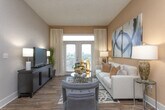Located along Monroe Drive NE in Atlanta, Georgia, this single-floor residence combines modern design with functional living across a thoughtfully arranged floor plan. The open-concept layout connects the kitchen, dining, and living areas seamlessly, creating a cohesive and inviting atmosphere throughout.

The kitchen is a standout feature, showcasing rich dark espresso cabinetry that extends to the ceiling, light granite countertops, a neutral stone tile backsplash, and a full suite of stainless steel appliances including a range, over-the-range microwave, and dishwasher. A peninsula with pendant lighting bridges the kitchen to the main living area, enhancing both functionality and style. Wood-look flooring runs through the kitchen and living spaces, adding warmth and continuity.

The living room is anchored by large French doors that invite natural light and provide an outdoor connection, complemented by warm neutral tones and hardwood-style flooring.

The bedrooms feature plush carpeting, large windows with sheer drapery, ceiling fans, and sophisticated gray accent walls that create a calm, restful ambiance. Each bedroom offers generous proportions with ample closet space, including a walk-in closet adjacent to one of the bathrooms.

The bathrooms maintain the refined aesthetic with granite countertops and neutral wall tones. The overall design throughout the residence is cohesive, blending contemporary finishes with a warm, livable character.