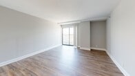 Located at 120 E Main St in the heart of downtown Lexington, KY, this one-bedroom, one-bathroom unit offers a well-designed layout with modern finishes throughout. Warm hardwood-style flooring runs continuously across all rooms, creating a cohesive and inviting atmosphere.

The kitchen is a standout feature, equipped with rich dark-espresso cabinetry, stainless steel appliances, a subway tile backsplash, and a granite-topped breakfast bar peninsula that flows into the combined living area. Recessed lighting illuminates the kitchen, enhancing its clean, contemporary feel.

The open living room is bright and airy, featuring neutral gray walls, generous natural light, and a sliding glass door that leads to a private balcony with outdoor views of the surrounding urban streetscape.

The bedroom is a comfortable, well-proportioned space with a large window offering city views, soft neutral walls, and a closet with paneled double doors. An additional closeted room provides flexible storage or utility space.

The bathroom features dark cabinetry with brushed nickel hardware, a white countertop, and a full tub-shower combination, maintaining the consistent design language found throughout the unit.

Overall, this space presents a clean, modern aesthetic with practical functionality, making it well-suited for urban living in downtown Lexington.
