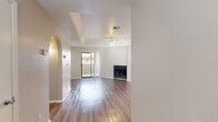 This well-appointed one-bedroom, one-bathroom unit in Sunland Park, New Mexico, offers a thoughtfully designed single-floor layout that maximizes comfort and functionality. The living room serves as the heart of the home, featuring smooth hardwood-style flooring, a tray ceiling with a ceiling fan, a cozy wood-burning fireplace, and a sliding glass door that opens to a private outdoor patio. A distinctive arched entryway connects the living room to the hallway and kitchen, adding a charming architectural detail throughout.

The galley-style kitchen is efficiently arranged with ample gray cabinetry, white countertops, a double stainless steel sink, and black appliances including a range, microwave, and refrigerator. Natural light filters in through a window at the end of the kitchen, brightening the space.

The bedroom is generously sized, finished with plush carpeting, a ceiling fan, and its own sliding glass door providing direct outdoor access. A dedicated closet with a rod and shelving offers organized storage. The bathroom is clean and functional, featuring a full tub-shower combination with tiled surround. A hallway connects all areas of the home, completing this cohesive and comfortable layout.