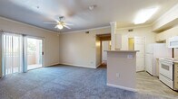 Located at 6410 Rocky Bluff Pt in Colorado Springs, Colorado, this single-floor residence offers a well-organized layout designed for comfortable everyday living. The open living area serves as the heart of the home, finished with plush carpeting, crown molding, and a ceiling fan with integrated lighting. A half-wall peninsula separates the living space from the galley-style kitchen, which features light wood cabinetry, laminate countertops, wood-look tile flooring, and white appliances including a range, microwave, dishwasher, and refrigerator. The primary bedroom is generously sized, complete with carpet, a ceiling fan, and sliding glass doors that open onto a private balcony. Additional bedrooms offer carpet, vertical blinds, and closet access, providing functional and flexible spaces. Two full bathrooms are appointed with wood-look tile flooring, soaking tubs, and tiled shower surrounds. A welcoming entry foyer with recessed lighting and a six-panel front door connects the living and bedroom wings. Throughout the residence, neutral warm-toned walls, consistent trim work, and crown molding create a cohesive and inviting atmosphere.
