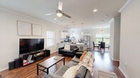 Located on Vista Drive in Clemson, SC, this well-appointed two-story home offers four bedrooms and four bathrooms across two generously sized floors. The main level features an open-concept layout where the living room, kitchen, and dining area flow seamlessly together. Rich hardwood flooring runs throughout the main floor, complemented by crown molding and recessed lighting. The kitchen is outfitted with stainless steel appliances, white shaker cabinetry, a subway tile backsplash, and pendant lighting over the counter, creating a clean, modern aesthetic. The adjacent dining area is brightened by large windows overlooking lush greenery, and is accented by a classic chandelier. The living room offers a comfortable gathering space with ceiling fan and front entry access. A dedicated laundry room with full-size washer and dryer is conveniently located on the main floor. Upstairs, the four bedrooms are carpeted and each equipped with ceiling fans, providing a comfortable retreat. The spacious primary bedroom offers ample room and private bathroom access. The bathrooms feature white vanities with updated fixtures and LED-lit mirrors. This home combines functional layout with modern finishes throughout.