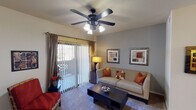 This single-floor residence offers a thoughtfully designed layout that balances comfort and functionality across its key living areas. The living room serves as the heart of the home, featuring plush carpeting, a ceiling fan with integrated lighting, and a sliding glass door that opens to a private balcony, flooding the space with natural light. Neutral and cool-toned accent walls complement the warm furnishings, creating an inviting atmosphere.

The kitchen is well-equipped with light wood cabinetry, granite-style countertops, and a full suite of appliances. A peninsula counter provides additional workspace and a casual dining option, while pendant lighting and hardwood-style flooring add a polished finish to the space.

The dining area is an intimate setting accented by a chandelier and a decorative wall mirror, offering a cozy spot for meals. The bedroom is a restful retreat with soft carpeting, dual windows dressed with curtains, a ceiling fan, and a walk-in closet. The bathroom features hardwood-style flooring, a granite-topped vanity, and a full shower-tub combination.

Throughout the residence, consistent design elements — including ceiling fans, warm wood tones, and neutral walls — create a cohesive and comfortable living environment.