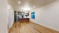 Located at 1509 Victoria St in Bozeman, MT, this thoughtfully designed 2-bedroom, 2-bathroom unit offers a contemporary living experience on a single floor. The open-concept kitchen and living area serves as the heart of the home, showcasing warm light hardwood floors, recessed lighting, and a striking chandelier overhead. The kitchen is outfitted with sage-green upper cabinetry, wood-toned lower cabinets, a white quartz waterfall island with an undermount sink, stainless steel appliances, and a white subway tile backsplash — a refined combination of form and function. A bold red entry door adds a distinctive architectural touch at the entrance, which also features hardwood flooring and large windows that invite natural light. Both bedrooms are carpeted and well-lit with multiple windows offering outdoor views. The two bathrooms are elegantly finished with marble-look large-format tile, wood-toned vanities, white quartz countertops, and matte black fixtures. One bathroom features a soaking tub and curved shower rod, while the other offers a walk-in shower with sliding barn-style glass doors and dark tile flooring. This unit delivers a clean, modern aesthetic with high-quality materials throughout.