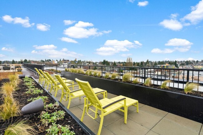 Rooftop deck with loungers, fire pit seating, and BBQ area - EdgePoint Apartments