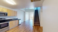 Located at 808 Fourth Avenue in the heart of San Diego, CA, this two-story residence offers a thoughtfully arranged floor plan spread across two levels. The main floor features warm hardwood-style flooring throughout, anchored by a well-appointed kitchen equipped with stainless steel appliances—including a refrigerator, range, microwave, and dishwasher—complemented by light maple cabinetry and dark granite-style countertops. The open-concept dining and living area benefits from floor-to-ceiling windows that flood the space with natural light and frame views of the surrounding cityscape. A carpeted staircase leads to the upper level, where additional rooms continue the bright, clean aesthetic with white walls and plush carpet flooring. A mirrored sliding-door closet adds a functional and visually expansive touch to the upper-level sleeping area. The bathroom features a full tub-shower combination, a wood-toned vanity with dark countertops, and hardwood-style flooring. Three closets provide ample storage throughout, and in-unit laundry adds everyday convenience. The crisp white walls, clean finishes, and abundant natural light contribute to a bright and airy ambiance throughout this centrally located San Diego residence.