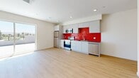 Located at 14629 Erwin St in Los Angeles, this modern 2-bedroom, 3-bathroom home offers a thoughtfully designed single-level layout with clean lines and contemporary finishes throughout. Light wood flooring flows seamlessly across the living spaces, complemented by crisp white walls and recessed lighting that create a bright, airy atmosphere.

The open-plan living area connects directly to a well-appointed kitchen, where sleek gray cabinetry and stainless steel appliances are elevated by a striking bold red tile backsplash — a standout design feature that adds vibrant character to the space. A sliding glass door in the living area provides direct access to the rooftop deck, flooding the interior with natural light.

The primary bedroom is generously sized, featuring large sliding glass doors that open onto the expansive rooftop terrace, offering sweeping views of palm trees and the Los Angeles skyline under sunny California skies. The second bedroom is equally bright, with a window that brings in natural light. Both rooms feature the same warm wood flooring found throughout the home.

The three bathrooms are finished in a modern style, with clean white cabinetry, dark countertops, large vanity mirrors, and wood-look flooring. The rooftop deck is a defining feature of this property, offering panoramic views of towering palms and the surrounding Van Nuys neighborhood — ideal for outdoor relaxation.