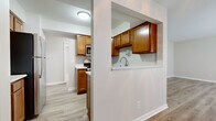 Located in Columbus, OH, this well-appointed 2-bedroom, 2-bathroom residence offers a practical and comfortable single-floor layout. The kitchen is a functional highlight, featuring warm honey-toned cabinetry, white countertops, stainless steel appliances including a gas range and built-in microwave, a double sink, and a pass-through window that connects to the living area. Light hardwood-style flooring flows throughout the main living areas, lending a clean and cohesive aesthetic. The combined kitchen and living room area provides an open, versatile space suitable for both everyday living and entertaining. The primary bedroom is generously sized, with hardwood-style flooring, neutral-toned walls, and a bay window that brings in natural light. The second bedroom features plush carpeting and a window, offering a cozy and quiet retreat. Both bathrooms are cleanly finished — one includes a full tub-shower combination with white tile surround, while the other features a wood-toned vanity with a light countertop and hardwood-style flooring. Throughout the residence, neutral color palettes, clean white trim, and consistent finishes create a cohesive and move-in-ready atmosphere.