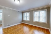 Located at 3701 Davenport St in Omaha, Nebraska, this one-bedroom, one-bathroom unit offers a well-organized and efficient floor plan spread across a single level. Warm-toned hardwood flooring runs throughout the living areas and bedroom, lending a classic character to the space. The living room is bright and welcoming, framed by large windows with white trim that invite ample natural light and offer views of the surrounding neighborhood. Crown molding adds a refined architectural detail throughout.

The bedroom is a comfortable, well-proportioned retreat featuring multiple windows that fill the room with natural light, neutral gray walls, and the same warm hardwood floors. A ceiling fan provides additional comfort and airflow.

The kitchen is practical and well-equipped, featuring light wood cabinetry, stainless steel appliances including a refrigerator, range, and over-the-range microwave, and tile flooring. A window above the counter area brings in natural light, making the space feel open and functional.

The bathroom presents a clean, classic aesthetic with white subway tile surrounding the tub-shower combination, a wall-mounted pedestal sink with brushed nickel fixtures, hex mosaic tile flooring, and a decorative frosted window that adds privacy while maintaining brightness. A hallway connects the rooms, completing this thoughtfully arranged and charming unit.