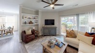 This 2-bedroom, 2-bathroom single-floor residence offers a thoughtfully designed layout that balances comfort and functionality. The living room serves as the heart of the home, featuring wood-look flooring in a herringbone pattern, crown molding, a ceiling fan, and built-in shelving. A sliding glass door opens directly onto a private balcony, filling the space with natural light and providing outdoor views.

Adjacent to the living area, the dining space accommodates a full-sized table and is brightened by large windows and a stylish pendant light. The kitchen is equipped with stainless steel appliances, ample cabinetry, and wood-look flooring that carries through from the main living areas.

The primary bedroom features plush carpeting, a ceiling fan, a walk-in closet, and a dedicated en-suite bathroom with a dual-sink vanity and a tub-shower combination with glass sliding doors. The second bedroom also offers carpeted flooring, a ceiling fan, and mirrored sliding closet doors that add depth to the room. The second bathroom includes a tub-shower combination with a curtain, wood-look flooring, and clean, neutral finishes. Together, these spaces create a cohesive and comfortable living environment.