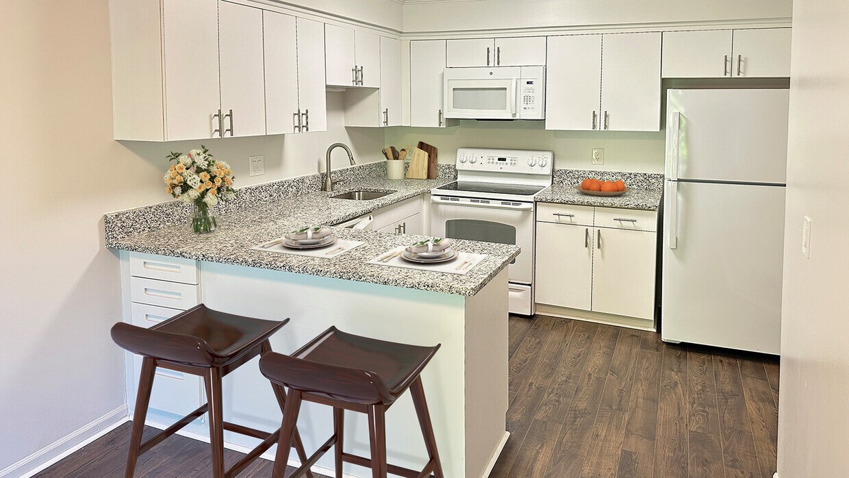 Amplia cocina gourmet con barra bistró, encimeras de granito, electrodomésticos de primera calidad y pisos de tablones de lujo. - Covington Club Luxury Homes