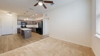 Located in Brooksville, FL, this single-story, 2-bedroom, 2-bathroom residence features a thoughtfully designed open-concept layout. The living area flows directly into the kitchen, which is equipped with dark cabinetry, black appliances including a refrigerator and range, a central island with pendant lighting, and wood-look flooring. A ceiling fan serves the living space, which transitions to carpeted flooring.

The spacious primary bedroom features carpet flooring, a ceiling fan, and direct access to an en-suite bathroom. That bathroom includes a single-sink vanity with wood cabinetry and stone-look countertop, wood-look tile flooring, a large mirror, and accessibility grab bars. The second bedroom is comparably sized, carpeted, and benefits from a window allowing natural light and outdoor views. The second bathroom mirrors the first in style, featuring a vanity with matching cabinetry and a tub-shower combination with grab bars and tile surround.

Throughout the residence, neutral wall tones, white panel doors, and consistent finishes create a clean, cohesive aesthetic. Ceiling fans appear in multiple rooms, and HVAC vents are centrally positioned for efficient climate control across the single-floor plan.