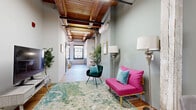 Located at 800 Broadway Blvd in the heart of Kansas City, MO, this one-bedroom, one-bathroom loft showcases a compelling blend of industrial character and contemporary design. The living area greets you with soaring exposed wood beam ceilings, light sage-green walls, and warm hardwood floors, creating an inviting and eclectic atmosphere. A wall-mounted mini-split system ensures year-round comfort, while the open layout maximizes the efficient use of the space.

The kitchen features crisp white cabinetry, a white subway tile backsplash, granite countertops, and a full suite of stainless steel appliances, including a dishwasher, range, and microwave — offering both style and functionality.

The spacious primary bedroom is bathed in natural light from dual windows with urban views of the surrounding historic Kansas City architecture. A sliding barn-style door adds an industrial touch and leads to the bathroom, which is finished with classic white subway tile in the walk-in shower, a white vanity, and rich hardwood flooring.

The overall ambiance is that of a thoughtfully designed urban loft, combining historic architectural details — most notably the striking exposed wooden ceiling beams — with clean, modern updates throughout every room.