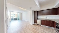 This contemporary 1-bedroom, 1-bathroom apartment at Slade at Channelside offers 710 square feet of efficiently designed living space. The open-concept floor plan seamlessly integrates the kitchen, living, and dining areas, creating a spacious feel. The kitchen is a standout feature, boasting rich, dark wood cabinetry, stainless steel appliances, and a stylish backsplash. The living area is bathed in natural light from large windows and sliding glass doors leading to a private balcony, offering views of the surrounding area. The bedroom, measuring 170 square feet, features a ceiling fan and ample closet space. The bathroom continues the modern aesthetic with a marble-topped vanity and a combination shower/tub. Throughout the apartment, light-toned wood-look flooring adds warmth and complements the overall design. The unit also includes in-unit laundry facilities, adding to its convenience. This apartment combines style and functionality, making it an ideal urban living space.