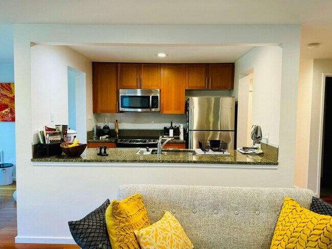 Sleek, fully equipped kitchen with granite countertops, stainless steel appliances, & wood cabinets - 2145 Dexter Ave N
