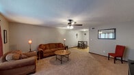 Located at 3410 Chisholm Rd in Florence, Alabama, this single-floor home offers a practical and comfortable layout with a warm, inviting ambiance throughout. The expansive main living area is carpeted and features a textured ceiling, a ceiling fan with light fixture, and neutral-toned walls that create a bright and open atmosphere. The living space flows seamlessly into a dining area, providing ample room for both relaxation and entertaining. Large windows allow natural light to fill the room, enhancing the sense of space. The kitchen is equipped with warm wood cabinetry, light countertops, a double-basin sink, and stainless steel appliances including a refrigerator and range, all set over easy-care light wood-style flooring. The bedroom is generously sized, finished with plush carpet, a ceiling fan, and a window dressed with light curtains that allow soft natural light to filter in. The bathroom features classic hexagonal tile flooring, a vanity with a light countertop, and a tub-shower combination. Throughout the home, consistent design choices including textured ceilings and neutral wall tones create a cohesive and functional living environment well-suited for everyday comfort.