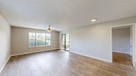 Located at 2121 Burwick Ave in Orange Park, Florida, this single-floor unit offers a thoughtfully designed layout that maximizes comfort and functionality. Light wood-look flooring runs throughout the space, complementing the neutral, warm-toned walls and creating a cohesive aesthetic from room to room.

The open-concept kitchen and living area serves as the heart of the unit. The kitchen is equipped with stainless steel appliances, including a refrigerator, electric range, and over-the-range microwave. Crisp white cabinetry provides ample storage, while the granite-topped peninsula with an undermount sink adds both workspace and a natural visual divide between the kitchen and living area. A louvered pantry closet adds additional storage convenience.

The living area is bright and airy, with natural light streaming through multiple windows fitted with blinds. A ceiling fan adds comfort and functionality to the space. Textured ceilings add a classic touch throughout the unit.

The bathroom is clean and modern, featuring white cabinetry, a granite-topped vanity, a framed mirror, and a full tub-shower combination. The walk-in closet is generously sized, outfitted with wire shelving on multiple walls, offering excellent organization potential. Together, these spaces create a practical and inviting home in Orange Park.