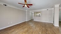 Located at 3400 Stratford Rd NE in Atlanta, GA, this well-appointed one-bedroom, one-bathroom residence offers a thoughtfully designed single-level layout. The galley-style kitchen is a standout feature, lined on both sides with white shaker cabinets, granite countertops, stainless steel appliances including a refrigerator, dishwasher, and microwave, and a double-basin sink — all set atop durable hardwood-style flooring. The kitchen flows conveniently into a dedicated pantry and laundry area, as well as a separate dining room. The spacious living room features crown molding, a ceiling fan, and natural light from a large window, with hardwood-style flooring extending throughout the main living areas. The generously sized bedroom is finished with plush carpeting, a ceiling fan, and a window overlooking surrounding trees, creating a comfortable and quiet retreat. A dedicated closet provides ample storage. The bathroom includes white cabinetry, a granite-topped vanity with a large mirror, and a full soaking tub. Neutral warm-gray tones throughout the home create a cohesive and inviting ambiance, while the inclusion of a hallway and pantry space adds practical functionality to the overall layout.