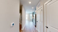 Located at 2220 Wilkinson Boulevard in Charlotte, NC, this thoughtfully designed one-bedroom, one-bathroom residence offers an efficient and modern single-floor layout. Light wood-tone luxury vinyl plank flooring flows continuously throughout the space, complemented by neutral gray walls and crisp white trim, creating a clean and cohesive aesthetic.

The open-concept living, dining, and kitchen area serves as the heart of the unit. Large windows flood the living area with natural light and offer views of the surrounding neighborhood. The kitchen is outfitted with sage green cabinetry with matte black hardware, white quartz countertops, a subway tile backsplash, and a full suite of stainless steel appliances, including a smooth-top range, over-the-range microwave, dishwasher, and full-size refrigerator.

The bedroom is a comfortable, well-proportioned retreat featuring a ceiling fan, a spacious double-door closet, and a window for natural light. The bathroom is finished with marble-look tile surrounding a full soaking tub and shower, paired with matte black fixtures for a contemporary touch. Additional conveniences include a dedicated laundry area and recessed lighting throughout. The unit combines modern finishes with practical functionality.