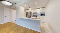 Located on the 8th floor at 5775 Boulevard Cavendish in Montréal, this well-appointed one-bedroom, one-bathroom unit offers a practical and comfortable layout. The open-concept kitchen and living area is a highlight, featuring white shaker-style cabinetry, stone countertops, a peninsula island with a built-in sink, stainless steel appliances including a refrigerator, electric range, and dishwasher, and tile flooring. Recessed lighting adds a clean, modern touch to the space. The living area transitions seamlessly to warm hardwood parquet flooring, which carries through to the bedroom, and leads to a private balcony accessible via sliding glass doors that invite natural light and outdoor views. The bedroom is a generous size with direct access to the full bathroom, which features classic subway tile surrounding a soaking tub and shower combination with chrome fixtures and tile flooring. A dedicated laundry room houses a full-size washer and dryer alongside upper cabinetry for added storage. A closet provides further organizational convenience. Neutral tones throughout create a bright, cohesive ambiance, making this a functional and welcoming urban residence.