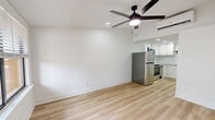 Located at 2875 Palumbo Dr in Lexington, KY, this efficiently laid-out studio offers a clean, modern aesthetic across a single floor. The combined kitchen and living area is anchored by light-toned hardwood flooring that runs throughout, creating a bright and cohesive feel. Crisp white walls and recessed lighting keep the space feeling open and airy, while a ceiling fan with a sleek black finish adds both function and style to the living area. A window with horizontal blinds allows natural light to filter in, offering a view of the surrounding greenery outside.

The kitchen is well-appointed with white shaker-style cabinetry accented by matte black hardware, a classic white subway tile backsplash, and stone-look countertops. Stainless steel appliances, including a full-size LG refrigerator and a range, provide modern functionality. A black utility sink faucet completes the kitchen's contemporary design. The kitchen flows naturally into the living space, making the layout practical for everyday use.

The bathroom features a clean, minimalist design with a shower/tub combination and a matte black towel bar accent, maintaining the consistent modern style found throughout the rest of the space. Overall, this studio presents a thoughtfully updated interior with a neutral palette ideal for comfortable, efficient living.