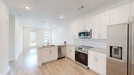 Located at 2652 S Main St NW in Kennesaw, GA, this well-appointed one-bedroom, one-bathroom residence offers a thoughtfully designed open-concept layout. Light hardwood-style flooring flows throughout the main living areas, creating a bright and cohesive feel.

The kitchen is a standout feature, showcasing crisp white shaker cabinetry that extends to the ceiling for ample storage, granite countertops, a classic subway tile backsplash, and a full suite of stainless steel appliances including a French door refrigerator, electric range, over-the-range microwave, and dishwasher. The kitchen transitions seamlessly into the living area, which is filled with natural light from a glass door and adjacent window offering outdoor views.

The bedroom is carpeted for comfort and includes a ceiling fan, a dedicated closet with built-in shelving, and a window with outdoor views. The full bathroom features a granite-topped vanity with an undermount sink, a tiled tub/shower combination, and a stacked in-unit washer and dryer. A clean entryway with an adjacent closet completes the functional layout. The unit presents a fresh, modern aesthetic throughout with a neutral color palette and recessed lighting.