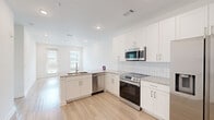 Located at 2652 S Main St NW in Kennesaw, GA, this well-appointed one-bedroom, one-bathroom residence offers a thoughtfully designed open-concept layout. Light hardwood-style flooring flows throughout the main living areas, creating a bright and cohesive feel.

The kitchen is a standout feature, showcasing crisp white shaker cabinetry that extends to the ceiling for ample storage, granite countertops, a classic subway tile backsplash, and a full suite of stainless steel appliances including a French door refrigerator, electric range, over-the-range microwave, and dishwasher. The kitchen transitions seamlessly into the living area, which is filled with natural light from a glass door and adjacent window offering outdoor views.

The bedroom is carpeted for comfort and includes a ceiling fan, a dedicated closet with built-in shelving, and a window with outdoor views. The full bathroom features a granite-topped vanity with an undermount sink, a tiled tub/shower combination, and a stacked in-unit washer and dryer. A clean entryway with an adjacent closet completes the functional layout. The unit presents a fresh, modern aesthetic throughout with a neutral color palette and recessed lighting.