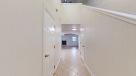Located at 2405 S 15th Pl in Rogers, Arkansas, this two-story home offers two bedrooms and three bathrooms across a thoughtfully organized floor plan. The main level houses the primary living areas, including a living room anchored by a tile-surround fireplace with a classic white mantle and wood-look tile flooring. An arched doorway connects the living room to the hallway, adding an elegant architectural detail. The kitchen features white cabinetry, dark granite countertops, stainless steel appliances including a refrigerator, range, and microwave, and recessed lighting overhead. Tile flooring extends throughout the main level's common areas.

Upstairs, the bedrooms are carpeted and include ceiling fans. The primary bedroom features vaulted ceilings and a walk-in closet with built-in shelving. The second bedroom offers multiple windows providing ample natural light. Three bathrooms are distributed across both floors, each finished with granite countertops and white cabinetry with brushed nickel hardware. A dedicated laundry room includes overhead storage cabinetry. The home's clean, neutral palette and consistent finishes create a cohesive and functional living environment throughout.