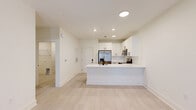 Located in Kathleen, Georgia, this thoughtfully designed single-floor unit offers a clean, modern aesthetic throughout its well-organized layout. The open-concept living and kitchen area serves as the heart of the home, anchored by a peninsula island with a white quartz countertop and a matte black single-basin sink. The kitchen is outfitted with crisp white shaker-style cabinetry with black hardware, a white subway tile backsplash, and a full suite of stainless steel appliances including a French door refrigerator, gas range, built-in microwave, and dishwasher. Light hardwood-style flooring flows seamlessly through the living area, creating a bright and cohesive atmosphere. Recessed lighting illuminates the kitchen and living space, enhancing the airy, contemporary feel. The living area features a ceiling fan and access to a private exterior door with a window allowing natural light to filter in. The bedroom is a comfortable, well-proportioned retreat with a ceiling fan, a window with blinds, and closet access. The bathroom is cleanly finished with a walk-in shower, toilet, and matte black fixtures and accessories. A dedicated utility room completes the functional layout of this well-appointed unit.