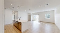 Located at 4965 Plainfield Ave NE in Grand Rapids, Michigan, this well-appointed 2-bedroom, 1-bathroom unit offers a clean, modern aesthetic throughout its single-floor layout. Light wood-style flooring flows seamlessly through every room, creating a bright and cohesive feel. Recessed lighting adds a polished touch to the open-concept kitchen and living area, where large sliding glass doors lead to a private balcony with views of the surrounding greenery.

The kitchen is a standout feature, centered around an expansive white quartz island with an integrated sink. Warm-toned cabinetry pairs with stainless steel appliances—including a range, microwave, and refrigerator—to create a functional and attractive cooking space. The open layout connects effortlessly to the generous living area, which is bathed in natural light.

The primary bedroom is a comfortable size and includes a walk-in closet outfitted with wire shelving for organized storage. The second bedroom features multiple windows fitted with horizontal blinds, allowing for excellent natural light and outdoor views. The full bathroom is finished with a wood-toned vanity, white countertop, and a tub-shower combination. A dedicated laundry area rounds out the practical features of this well-designed space.