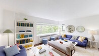 Located at 1717 SW Park Ave. in Portland, Oregon, this 2-bedroom, 1-bathroom unit offers a thoughtfully designed single-floor layout. The entrance leads into a clean, white-walled corridor that opens to a generous living room filled with natural light from a wide, panoramic window framing verdant tree canopy views. The living area features hardwood flooring, ample space for seating arrangements, and a built-in bookshelf, creating a comfortable and functional gathering space. The galley-style kitchen is outfitted with dark espresso cabinetry, light quartz countertops, a tile backsplash, stainless steel appliances including a refrigerator, range, microwave, and dishwasher, and a deep double sink. The primary bedroom is a serene retreat with herringbone-patterned accent wallpaper, hardwood floors, a large pendant light fixture, a closet, and a window overlooking greenery. The second bedroom offers a creative atmosphere with a bold geometric accent wall, ceiling fan, carpeting, and a window with natural light. The full bathroom includes a pedestal sink, mirrored medicine cabinet, and a tub-shower combination. Three closets throughout the unit provide ample storage.
