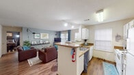 Located at 3535 E 10th St in Greenville, NC, this single-floor multi-bedroom residence offers a well-designed layout suited for shared living. The open-concept kitchen and living area form the heart of the unit, where a peninsula with granite-style countertops and white cabinetry flows seamlessly into a bright, comfortable living room. Hardwood-style flooring, track lighting, and large windows with teal curtains contribute to an airy, welcoming atmosphere.

The kitchen features ample counter space on both sides of the peninsula, a stainless steel sink, white cabinetry, and a dedicated windowed nook — ideal as a pantry or utility space. The living area is generously proportioned, with soft blue-grey walls and multiple windows that invite natural light.

The unit includes several distinctly styled bedrooms. One features a bold red accent wall with carpet flooring and a mirrored closet. Another showcases deep blue-grey tones with warm wall sconces. Additional bedrooms offer carpet flooring, sliding mirrored closets, and windows with natural light, with one also accommodating a built-in desk area.

Two full bathrooms serve the unit — one with a double-sink vanity and shower, the other with a single vanity, hardwood-style flooring, and a tub-shower combo. Throughout, the layout prioritizes functionality and comfort.