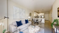 Located at 1825 San Jacinto St in the heart of Houston, TX, this well-appointed one-bedroom, one-bathroom residence offers a thoughtfully designed open-concept layout with modern finishes throughout. The living room serves as a bright, welcoming centerpiece, featuring polished concrete floors, neutral warm-toned walls, and French doors that invite abundant natural light and outdoor views. The space flows seamlessly into the dining area and kitchen, creating an ideal environment for both relaxing and entertaining. The kitchen is a standout feature, boasting sleek white cabinetry extending to the ceiling, a crisp white quartz peninsula with an undermount sink, a grey tile backsplash, and a full suite of stainless steel appliances including a gas range, microwave, dishwasher, and French door refrigerator. Pendant lighting adds a refined touch above the peninsula. The bedroom is a serene retreat with a tray ceiling, plush carpeting, and large windows that frame outdoor views, filling the room with natural light. The full bathroom offers a long white vanity with ample storage, a wide mirror, and a tub-shower combination. The walk-in closet provides generous built-in shelving, hanging rods, and a full-length mirror, maximizing organization and functionality throughout this efficiently designed urban residence.