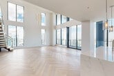 Located in the heart of Fort Lauderdale, this two-story, 4-bedroom, 3-bathroom residence offers a refined blend of modern design and elevated living. The main level welcomes you into a dramatic double-height living room bathed in natural light from expansive floor-to-ceiling windows, revealing sweeping panoramic views of the Fort Lauderdale skyline. A sleek gold linear chandelier adds an elegant focal point overhead, while light-toned herringbone wood flooring flows seamlessly throughout both levels. The gourmet kitchen is appointed with rich walnut cabinetry, stainless steel appliances including a double wall oven, a cooktop with a steel range hood, and a striking marble-topped island. The bathrooms are finished to a high standard, featuring warm wood vanities, white quartz countertops, and glass-enclosed showers with floor-to-ceiling marble tile surround. A modern staircase with glass panel railings and wood-capped handrails connects the two levels with architectural flair. The upper floor houses the expansive primary suite and additional bedrooms, each framed by tall windows capturing breathtaking city views. Built-in closet systems provide organized storage throughout. Every detail of this residence reflects meticulous craftsmanship and contemporary elegance.