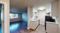 Located at 1030 S Chelton Rd in Colorado Springs, Colorado, this single-floor unit offers a clean, functional layout designed for comfortable everyday living. The open-concept area connecting the kitchen and living room creates a welcoming, cohesive space. The kitchen is thoughtfully appointed with white cabinetry extending to the ceiling for ample storage, granite-style countertops, a stainless steel sink, and black appliances including a refrigerator and electric range with an overhead ventilation hood. Light wood-style flooring runs throughout the kitchen, while rich, dark hardwood-style flooring anchors the living areas, adding warmth and visual contrast. The spacious living room features a large window that allows natural light to fill the room and includes baseboard heating for year-round comfort. The bedroom is generously sized with a built-in closet and continuity of the hardwood-style flooring, offering a calm and practical retreat. The bathroom is finished in a clean, neutral palette with a tiled shower-tub combination, brushed nickel fixtures, and a hardwood-style floor. Textured ceilings are present throughout, and the overall aesthetic is bright, neutral, and move-in ready.