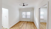 Located at 132 S Westmoreland Ave in the vibrant Koreatown neighborhood of Los Angeles, this single-story home offers a clean, updated interior with a cohesive design throughout. Warm-toned hardwood-style flooring runs through the main living areas and bedrooms, lending continuity and a bright, welcoming feel to the space.

The kitchen stands out as a well-appointed feature, showcasing gray shaker-style cabinetry paired with granite countertops, a stainless steel gas range with an overhead vent hood, and a stainless steel sink — combining functionality with modern aesthetics.

Multiple rooms benefit from generous natural light streaming through white-slatted blinds. Ceiling fans are present in several rooms, providing comfortable air circulation. One room includes a wall-mounted gas heater, offering an additional heating option. The layout, as seen in the dollhouse view, presents a straightforward and practical floor plan with well-defined living, sleeping, and utility spaces.

The bathroom is finished with warm beige tile surrounding a full soaking tub and shower combination, complemented by a tile floor, a vanity with sink, and a frosted window that brings in natural light while maintaining privacy. The overall ambiance of this home is bright, clean, and move-in ready.